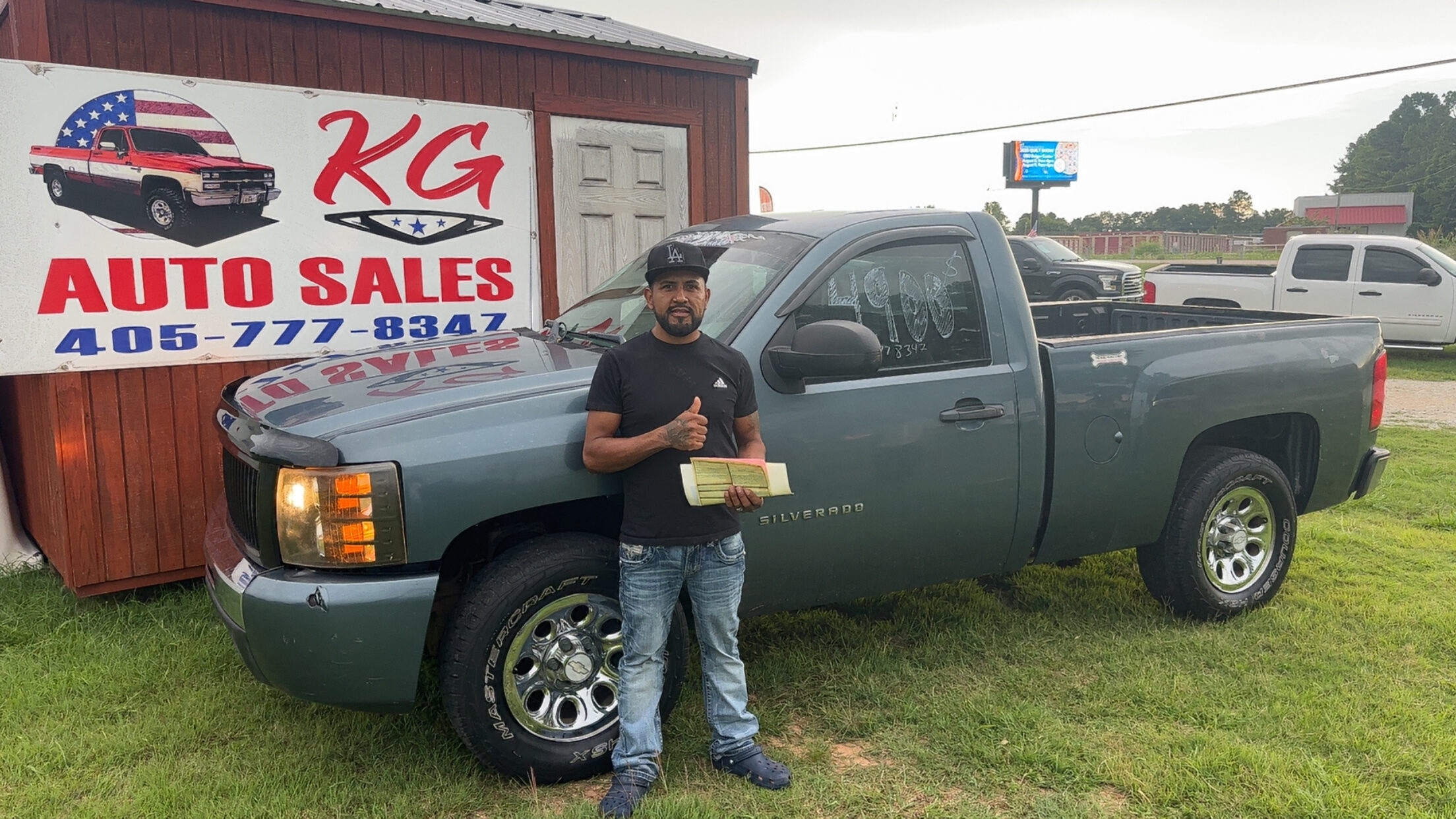 Happy customer poses with their vehicle purchased at KG Auto Sales lot.