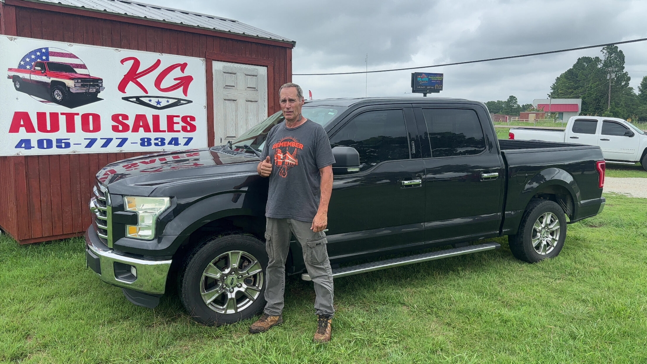Happy customer poses with their vehicle purchased at KG Auto Sales lot.